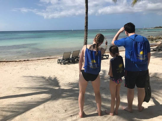 Clients at the Barcelo Maya Palace with their Enlighten Excursions drawstring beach bags.