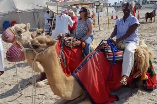 Two women seated on camels