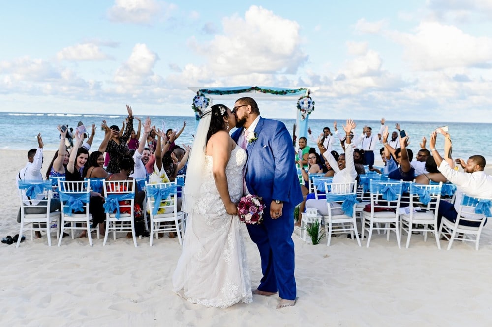 Bride and Groom exiting their beach destination wedding kissing